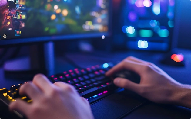 De handen van een gamer op het toetsenbord en de muis tijdens het online gamen op een computer met RGB-verlichting ’s nachts.