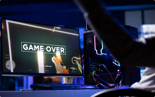 De gamer gooit teleurgesteld zijn koptelefoon weg na zijn nederlaag; op het scherm verschijnt de tekst „Game Over“.